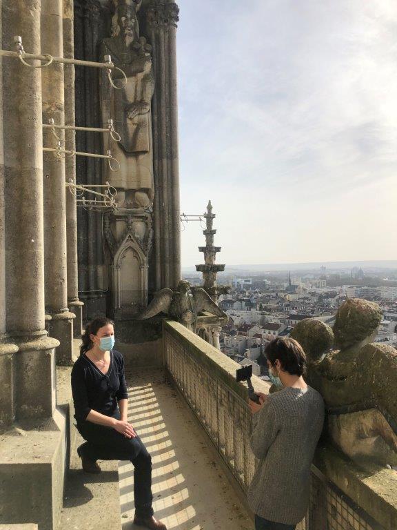 Visite en direct des tours de la cathédrale de Reims : un vidéaste de dos filme une intervenante