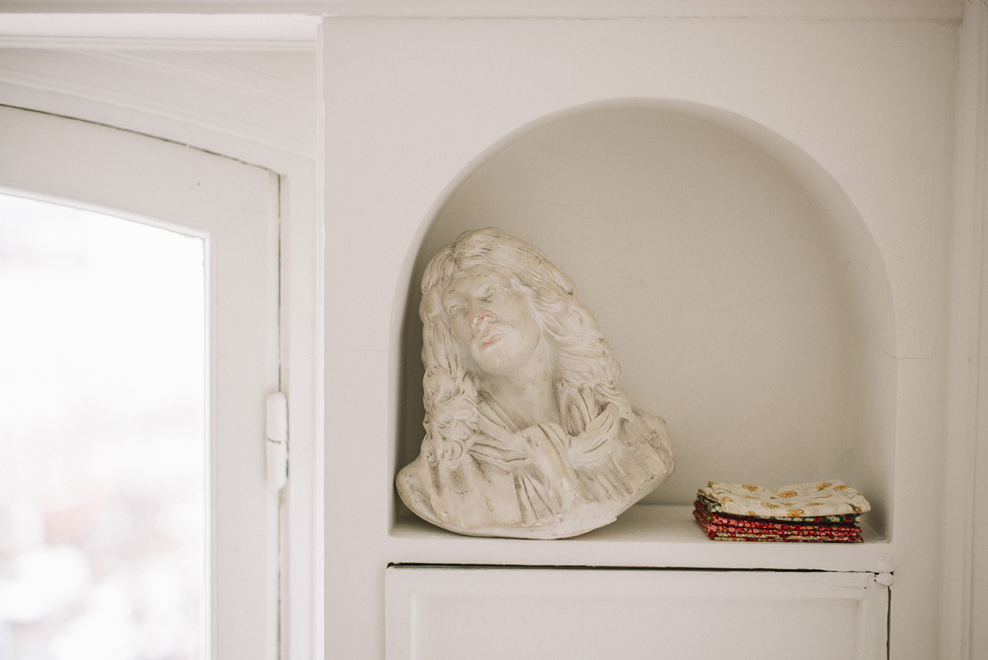 Buste de Molière dans une niche au côté de tissus pliés