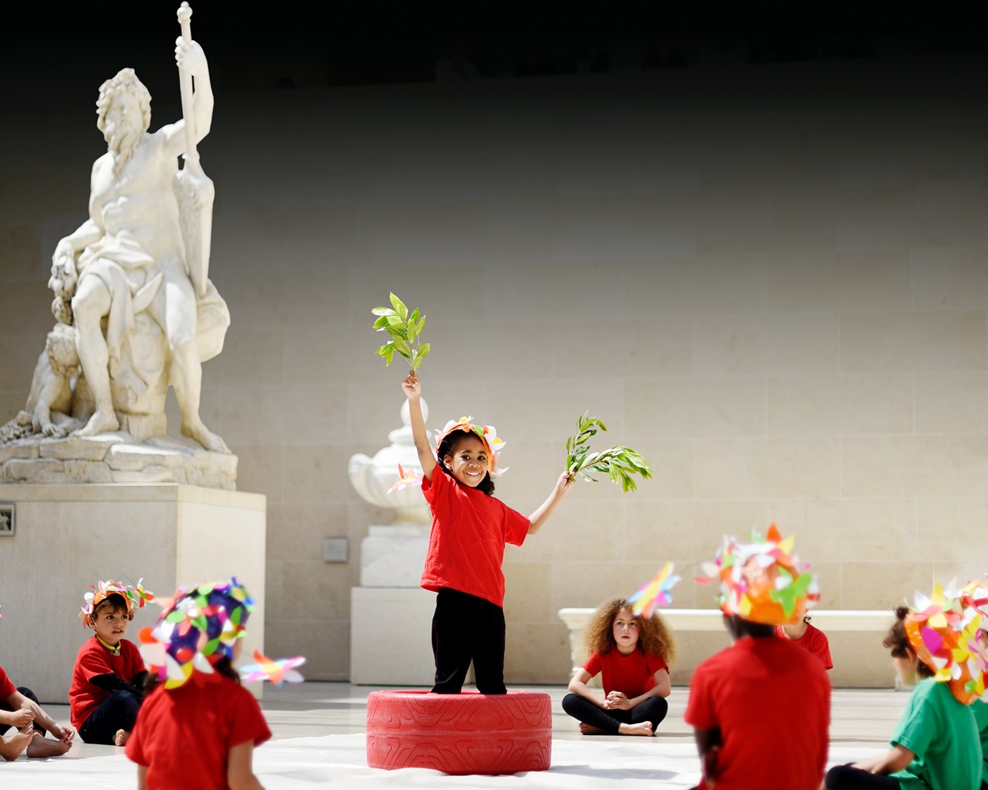Des écoliers jouent une scène devant La Seine d’Antoine Coysevox au musée du Louvre