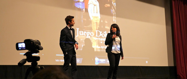 À l’écran, l’affiche du film ‘Juego doble’ présenté par un lycéen et une lycéenne