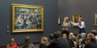 Une intervenante commente le Bal du moulin de la Galette d’Auguste Renoir au musée d’Orsay