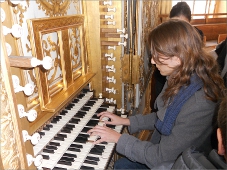 Une jeune organiste joue sur un orgue à 4 claviers