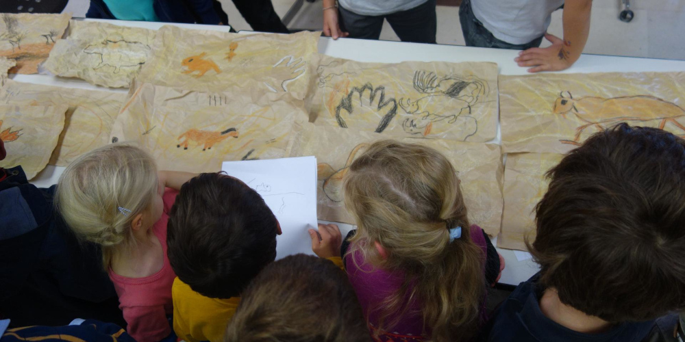 Des enfants reconstituent sur papier une fresque pariétale