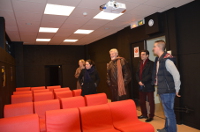 M. Patrick Préjean visite la salle de projection équipée de fauteuils rouges